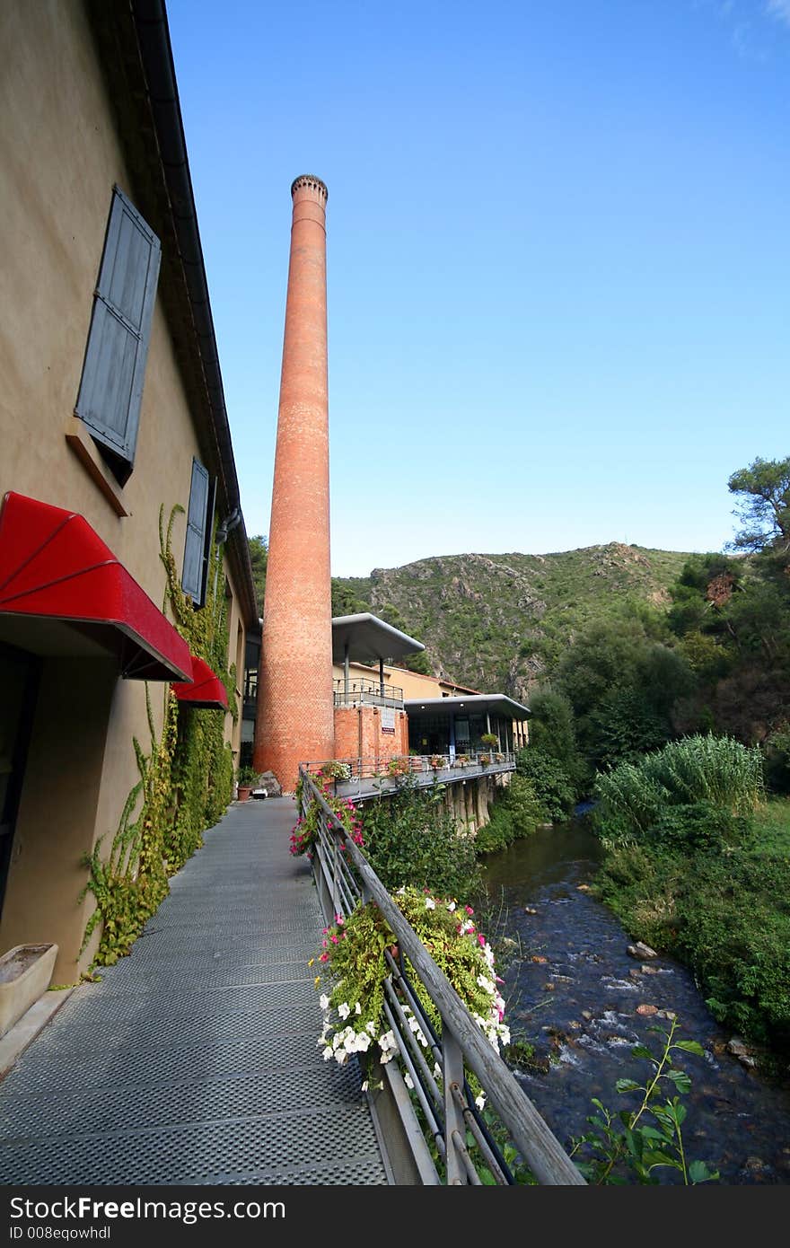 Factory with chimney along a river. Factory with chimney along a river