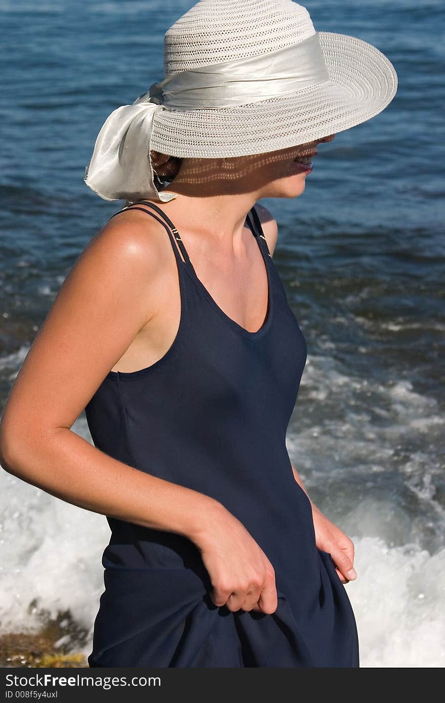 Lady in a dark blue dress and a hat. Lady in a dark blue dress and a hat