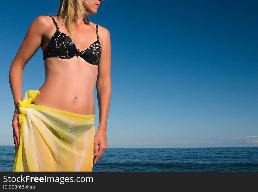 The girl with a yellow scarf on a sea background. The girl with a yellow scarf on a sea background