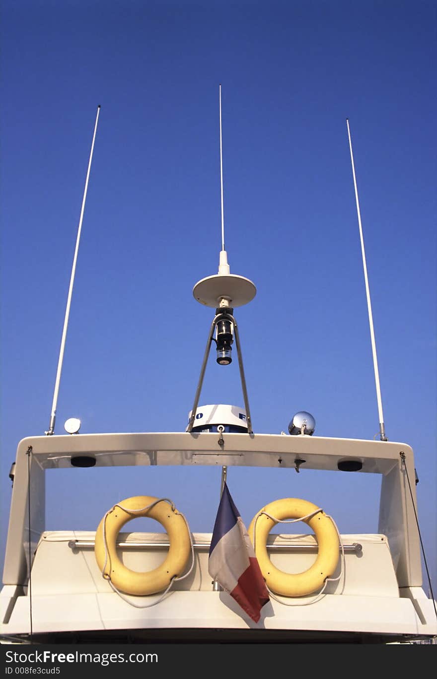 Top of a cruise ship showing buoys, radar, alarms antenna and a french flag. Top of a cruise ship showing buoys, radar, alarms antenna and a french flag.