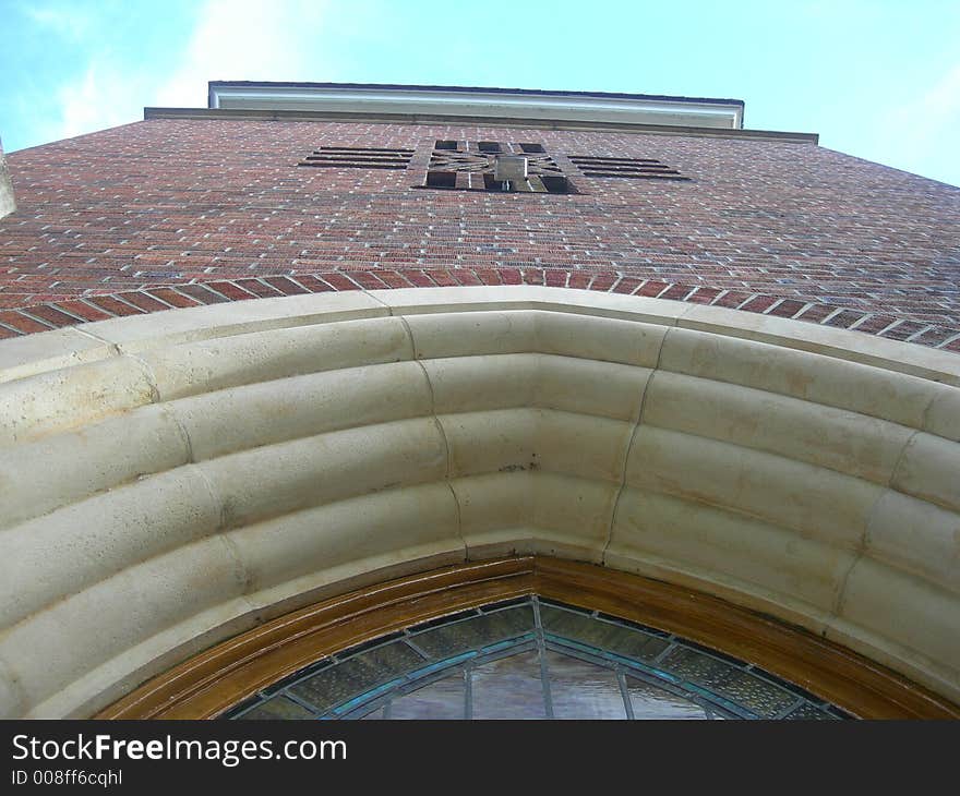 Picture of a Methodist church tower. Cross is formed in the bricks in the middle of the tower.