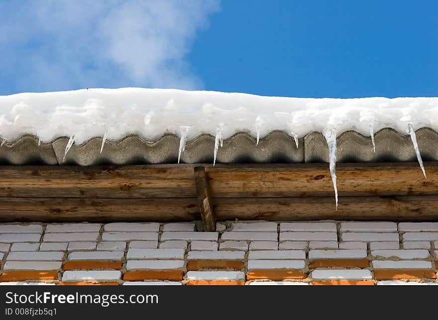 Snow covered roof with icicles