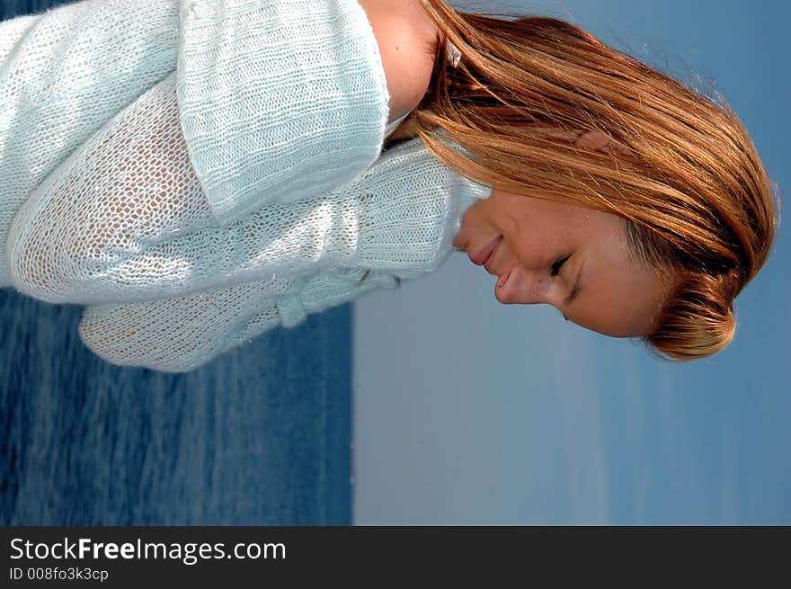 A pretty teen keeping warm in a sweater by the ocean. A pretty teen keeping warm in a sweater by the ocean