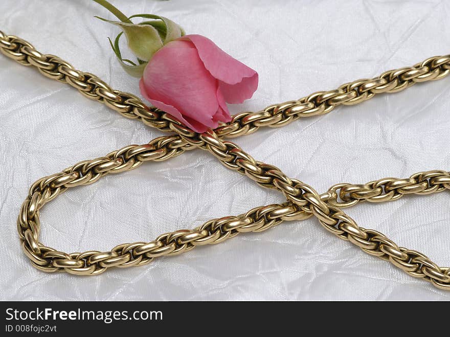 Gold chain and pink rose