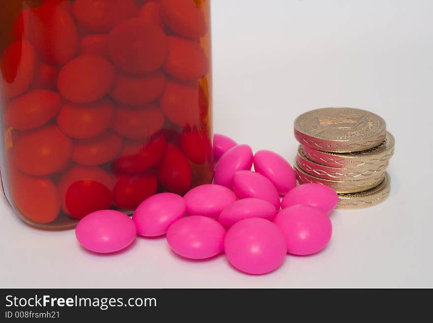 Some pills and coins describing the cost of drugs. Some pills and coins describing the cost of drugs