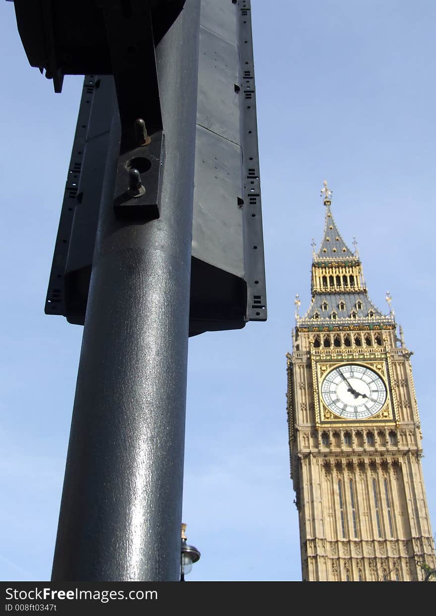 A image of the houses of Parliament sometimes nicknamed Big Ben which is located in central London. Also their is a traffic light in the image giving  a typical London City view.