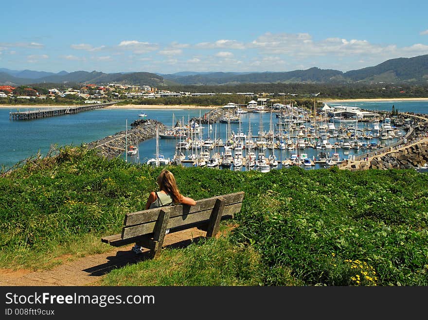 Girl Sitting On A Bench Overlooking The Marina