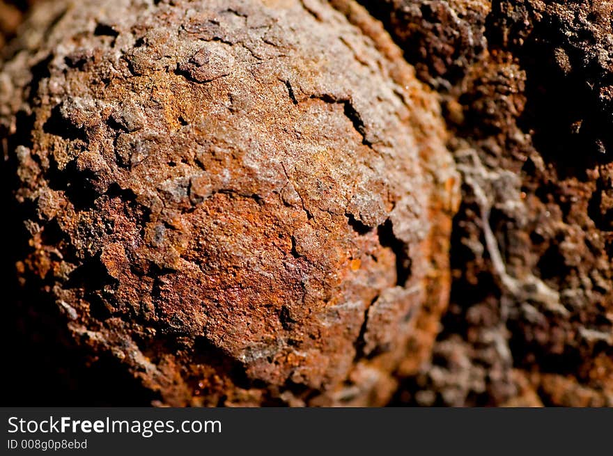 Closeup of a rusty bolt on a railroad underpass.