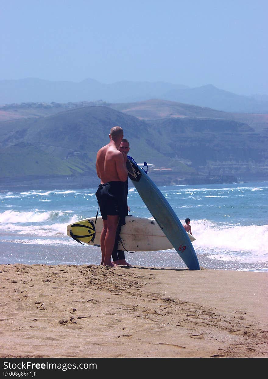 Two surfers waiting for the right shore break to surf.