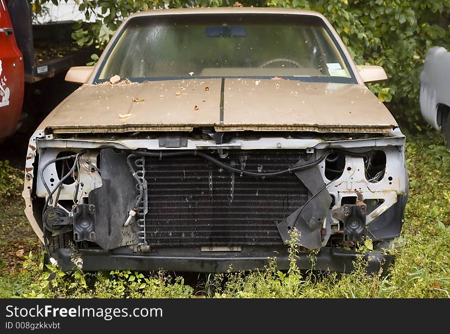 Wrecked car outside of bodyshop missing front end parts. Wrecked car outside of bodyshop missing front end parts