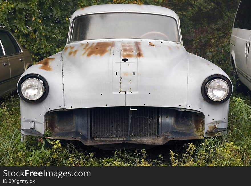 Circa 1950 car missing front end parts sitting in weeds. Circa 1950 car missing front end parts sitting in weeds