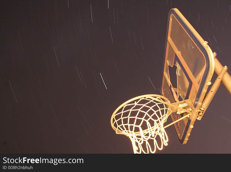 Long exposure of star trails with a bsketball hoop in the foreground