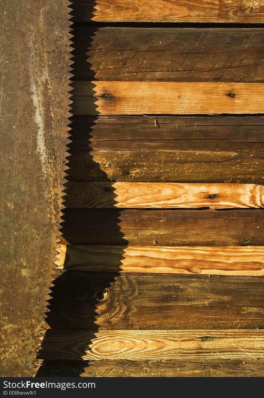 Saw with a shadow on a wall of a shed