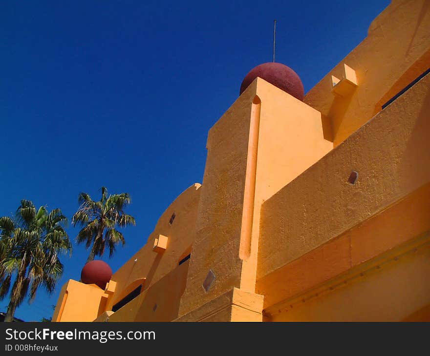 Building detail with blue sky and palm trees