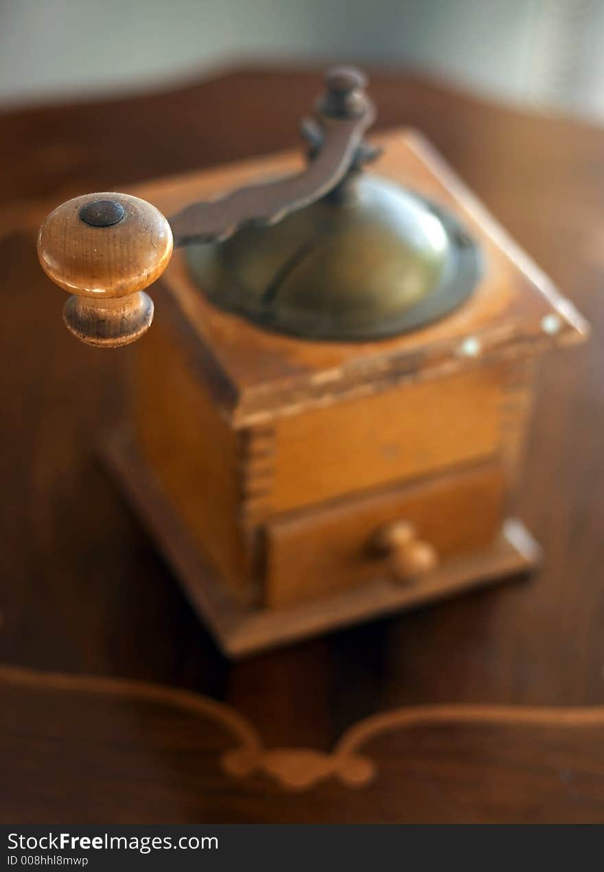 Old coffe grinder on wood table.