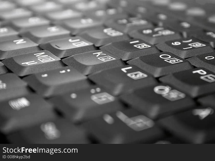 Detail view on gray laptop keys. Shallow depth of field. Focus on M, K, O. Detail view on gray laptop keys. Shallow depth of field. Focus on M, K, O.