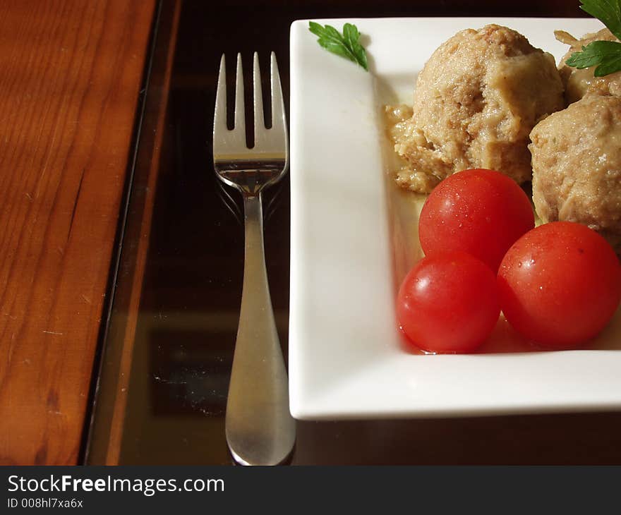 Meatballs in onion sauce whit cherry tomatoes and a cup of white wine