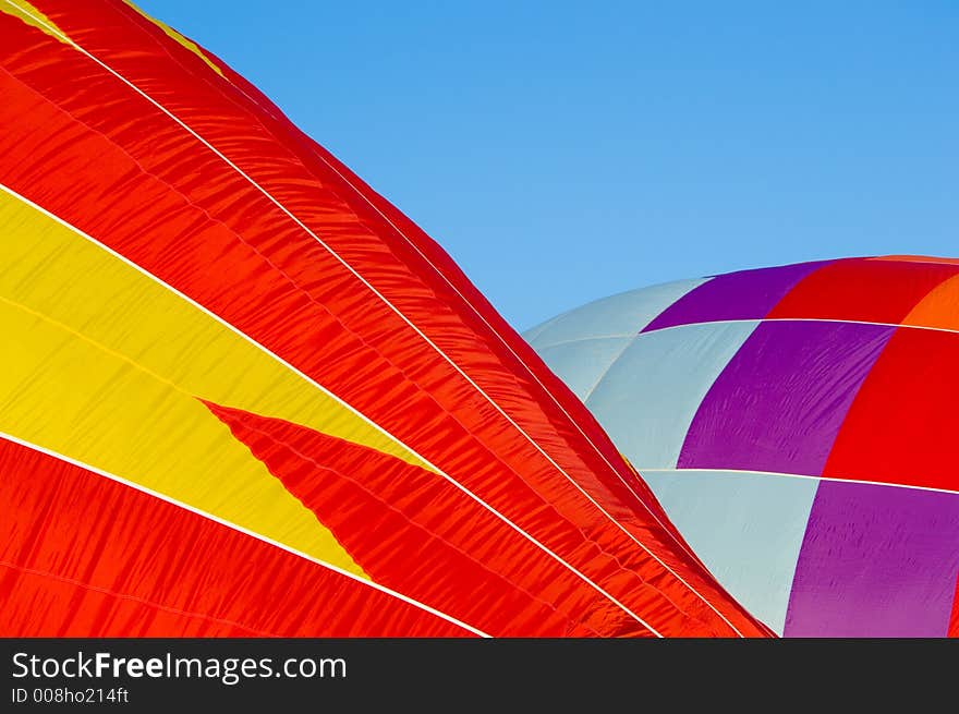 Beautiful hot air balloon preparing for launch against dark blue sky