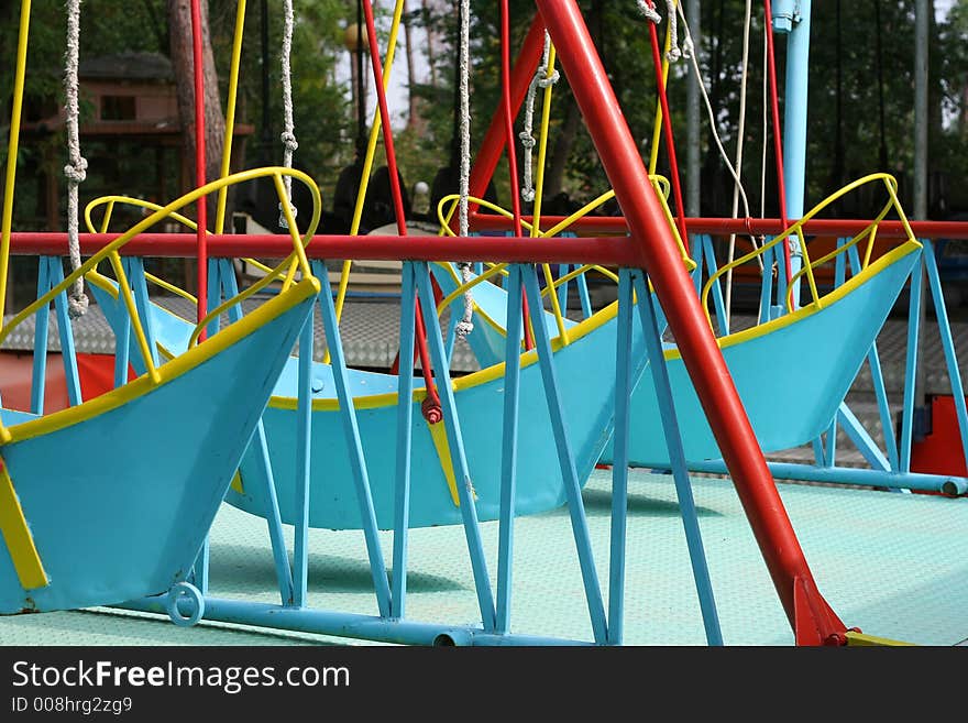 Boat-like swings in a fair-ground. Boat-like swings in a fair-ground