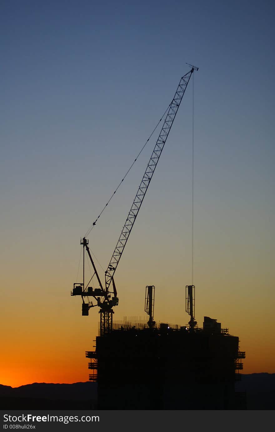 A construction site with the sun coming up behind it, silhouette. A construction site with the sun coming up behind it, silhouette