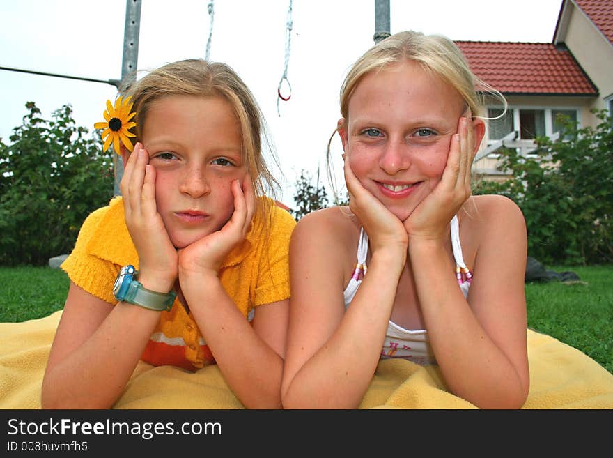 Girl friends posing on blanket in garden. Girl friends posing on blanket in garden