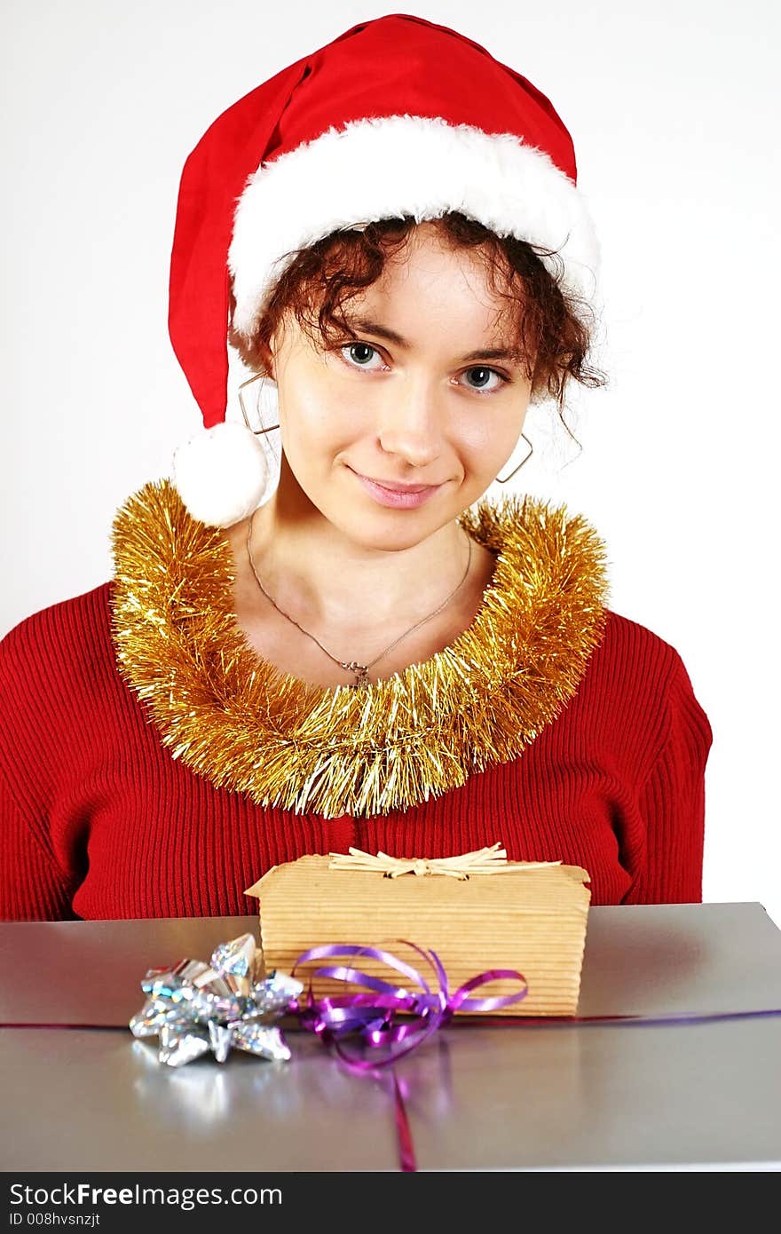 Young woman in a red and white santa fancy hat with presents. Young woman in a red and white santa fancy hat with presents