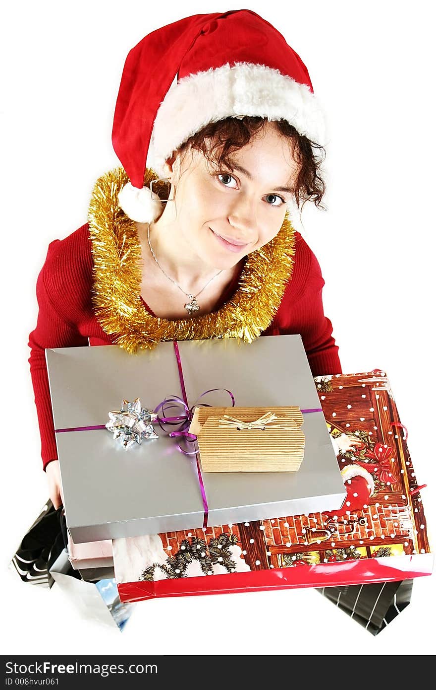 Young woman in  a red and white santa fancy hat with presents. Young woman in  a red and white santa fancy hat with presents