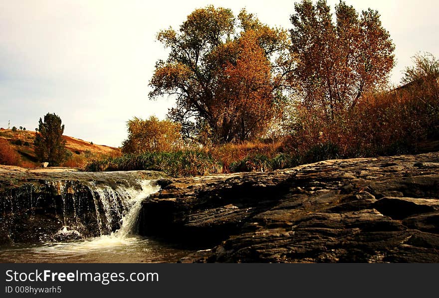 A flowing stream with rocks and trees in Colorado. A flowing stream with rocks and trees in Colorado.