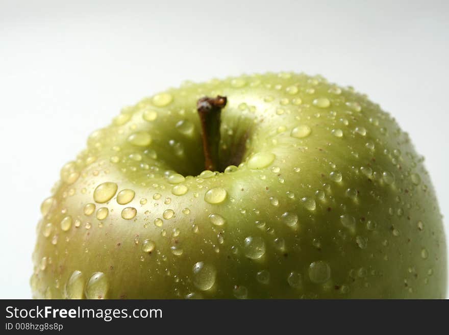 Juicy fresh apples separately from a background with drops of water on a leather