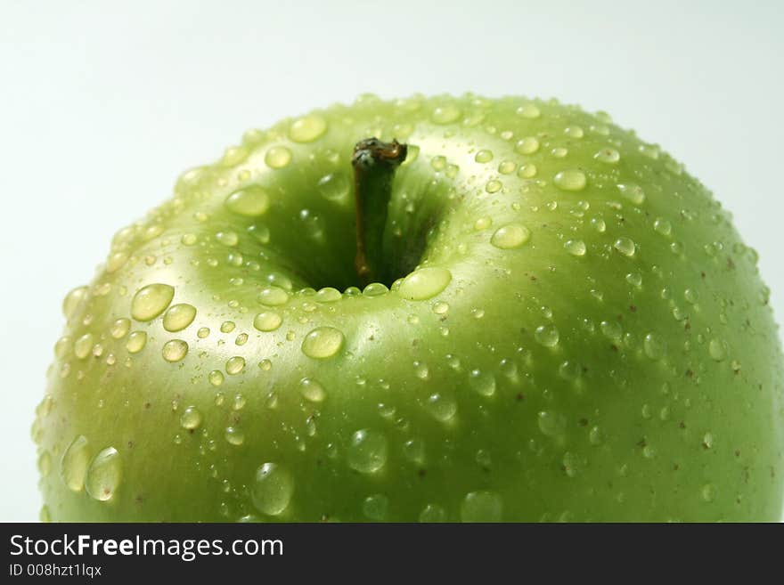 Juicy fresh apples separately from a background with drops of water on a leather