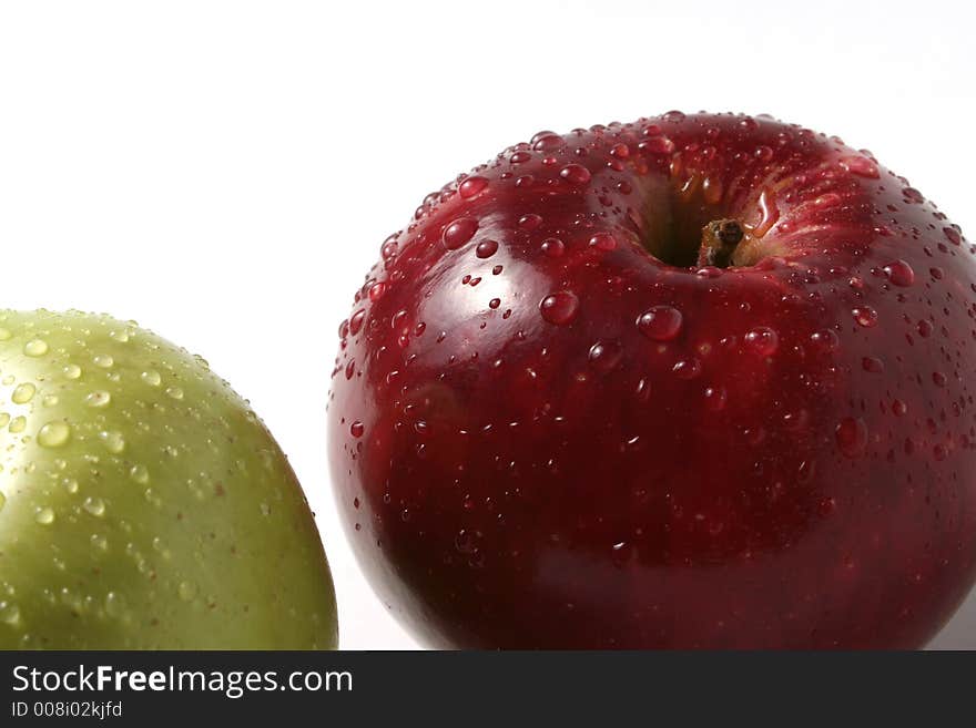 Juicy fresh apples separately from a background with drops of water on a leather