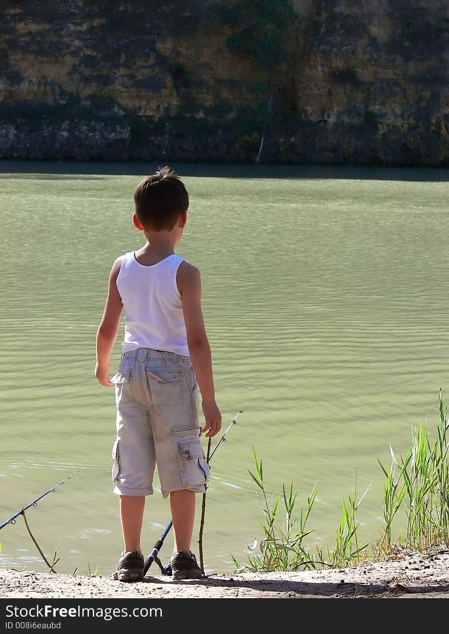 A boy fishing on the banks of a river