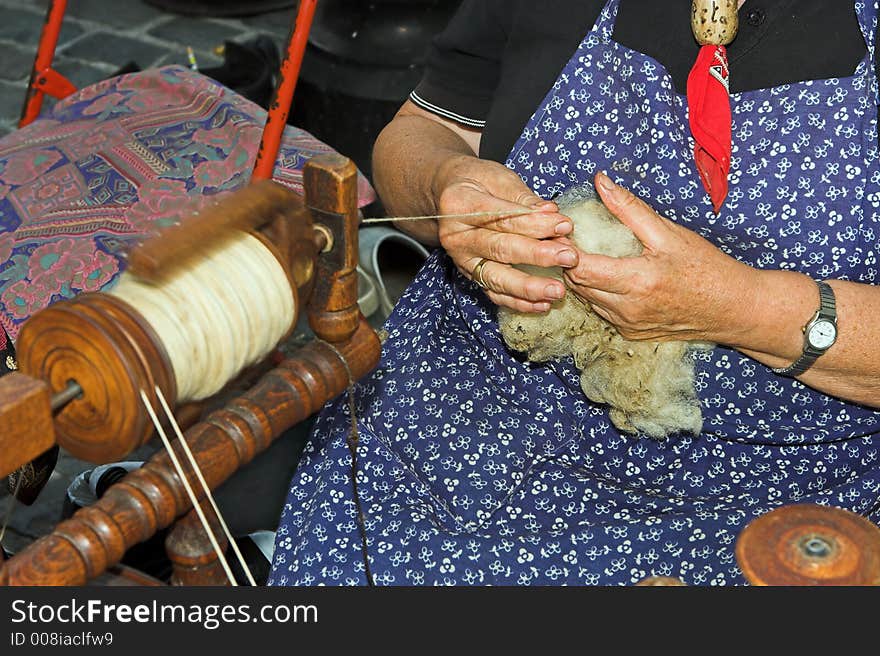 Woman spinning wool with a spinning wheel