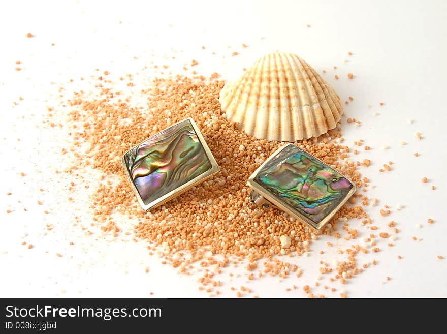 Shell and earrings on beachsand