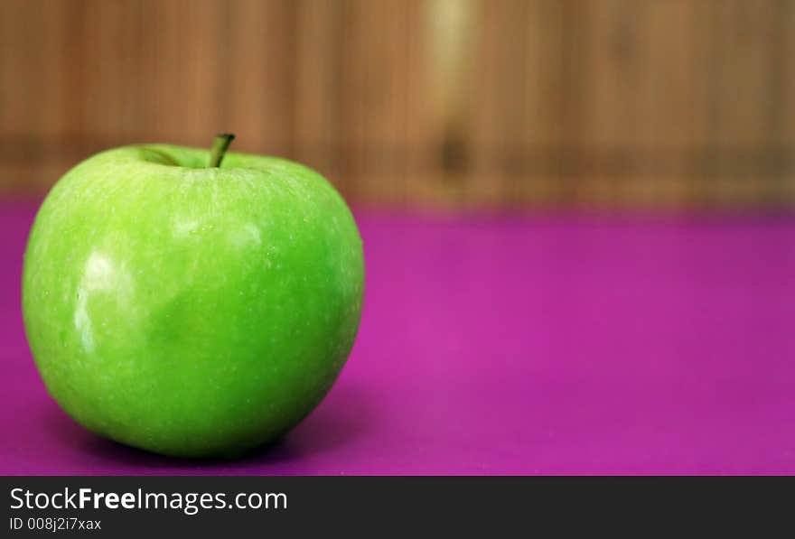 Green apple on pink background