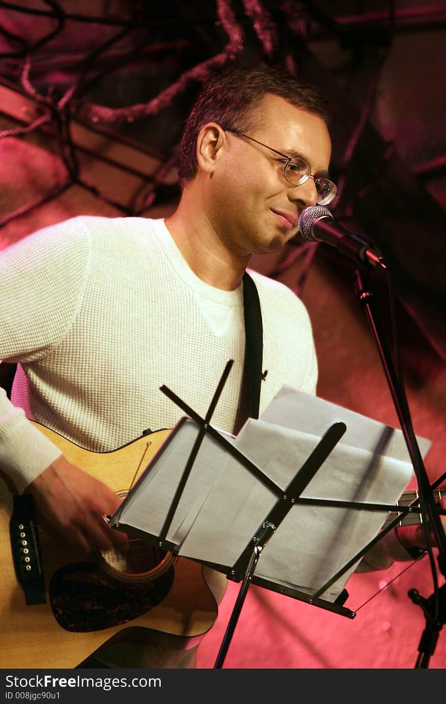 Man playing acoustic guitar on the stage. Man playing acoustic guitar on the stage