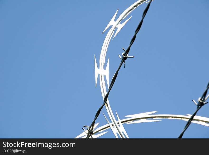 Close-up of razor wire security fence in bright sun