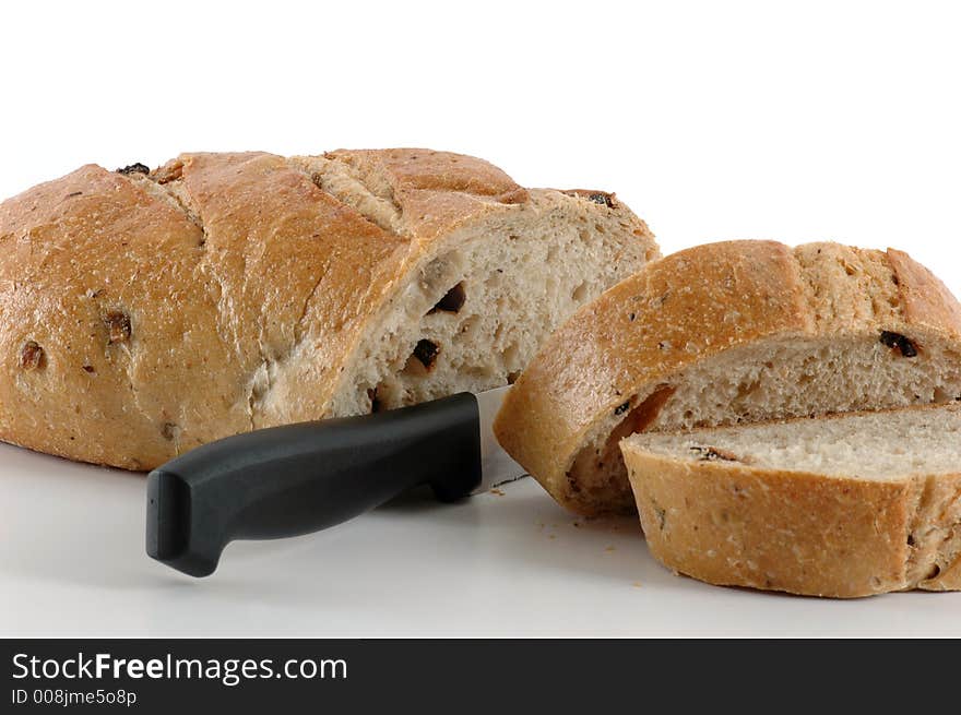 Slicing hearty pieces of fresh baked olive loaf. Slicing hearty pieces of fresh baked olive loaf.