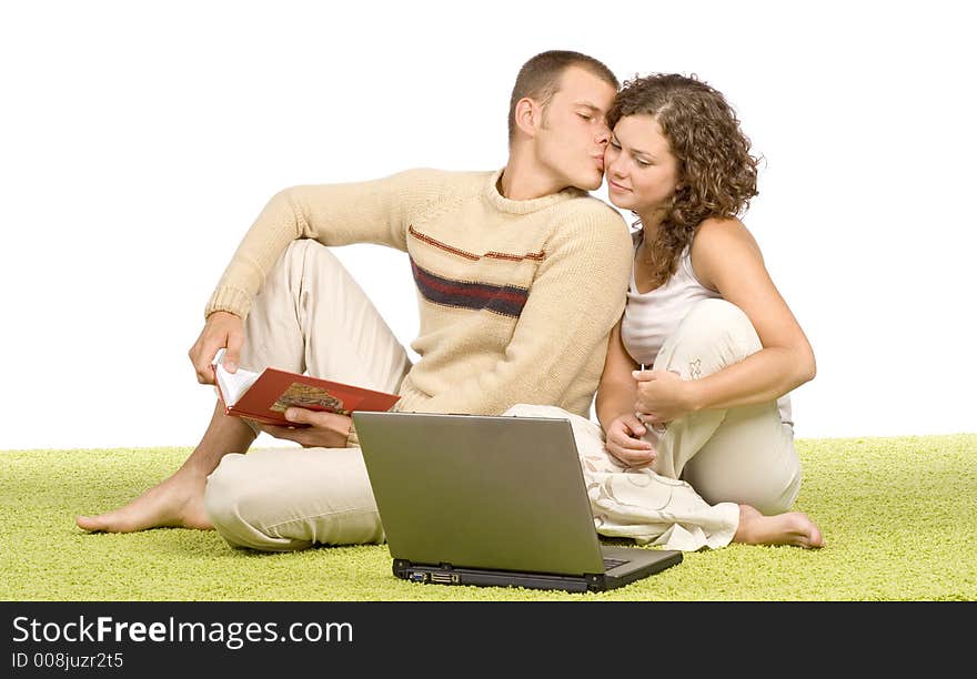 Isolated on white young couple on green carpet with laptop and book