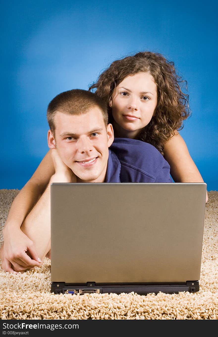 Young couple on the beige carpet with laptop. Young couple on the beige carpet with laptop