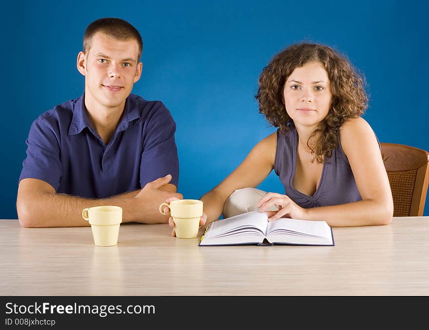 Young couple at the table with book