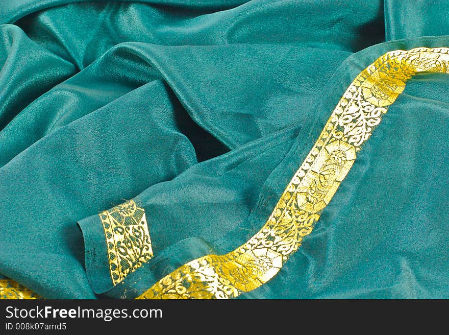 Scrunched up green satin fabric with a gold border. Scrunched up green satin fabric with a gold border