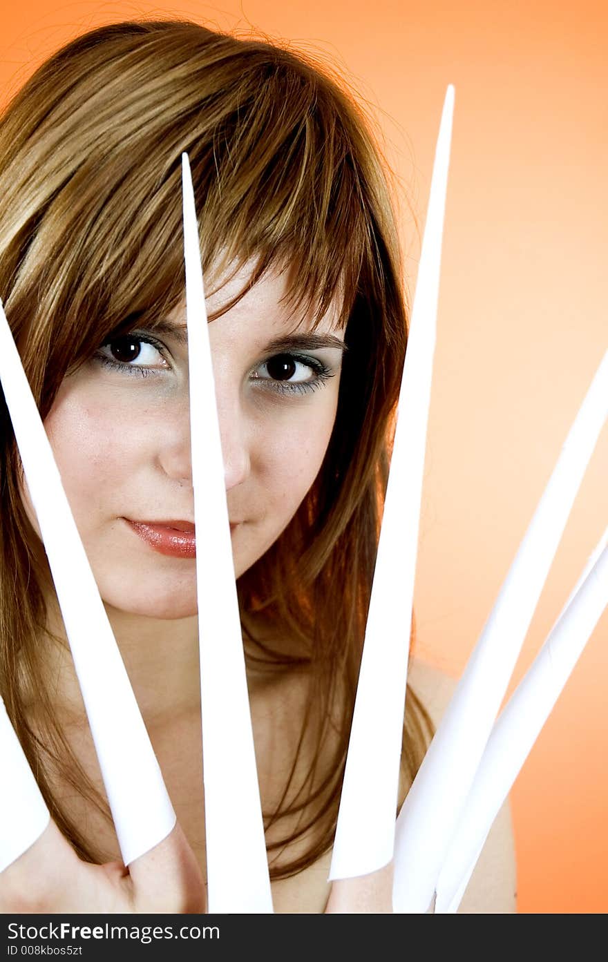 Funny looking cute girl poses with scissor fingers made out of paper - Freddy Kruger style