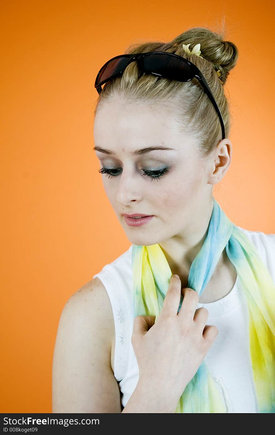 Portrait of a beautiful young blond with casual clothes posing in a studio; nice looks and make-up; isolated on orange. Portrait of a beautiful young blond with casual clothes posing in a studio; nice looks and make-up; isolated on orange