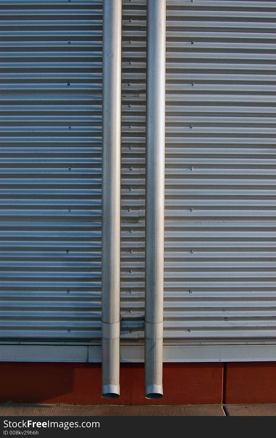 Drain pipes against a sheet metal exterior wall. Drain pipes against a sheet metal exterior wall.