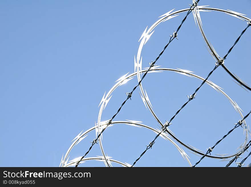 Razor wire on chain link security fence. Razor wire on chain link security fence