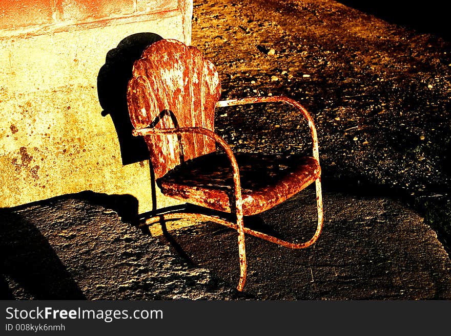 Old rusty metal chair shot outside a barn. Old rusty metal chair shot outside a barn