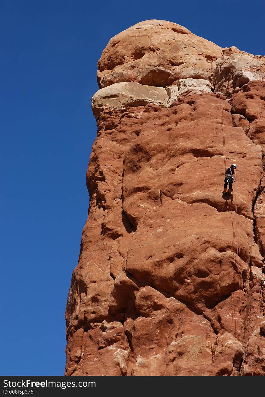 Woman rapelling off desert tower