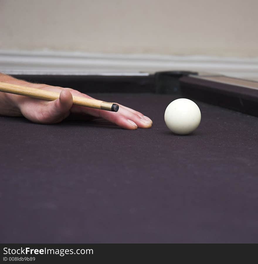 Pool player cueing up to strike cue ball. Pool player cueing up to strike cue ball.