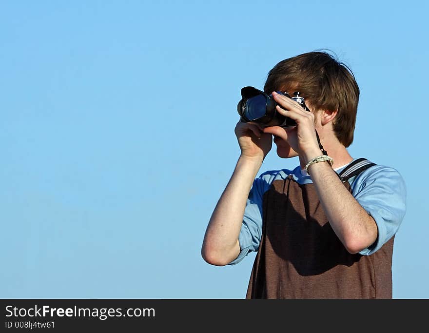 Boy in brown-blue shirt taking a picture. Boy in brown-blue shirt taking a picture